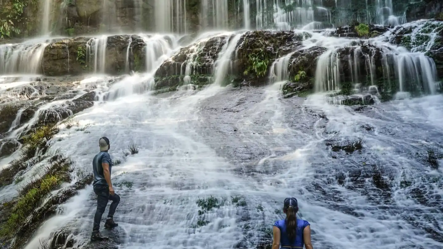 Deux personnes debout devant une chute d’eau