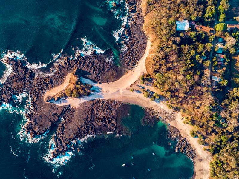 Une vue aérienne d’une plage de sable et de l’océan.