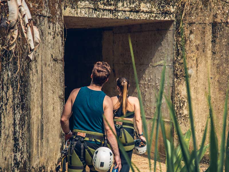 Un homme et une femme sortent d’une grotte.