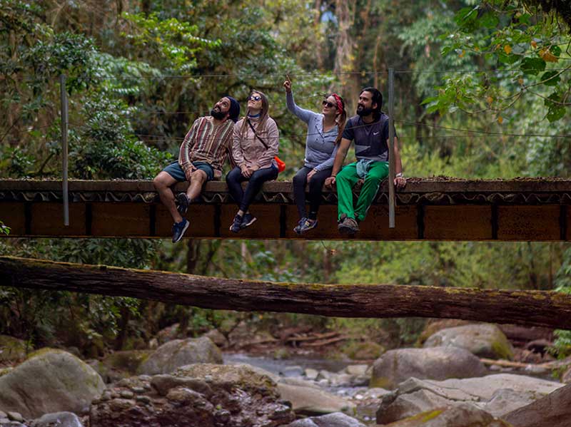 Un groupe de personnes assises sur un pont au-dessus d’une rivière.