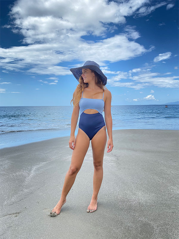 Une femme debout sur une plage en bikini.