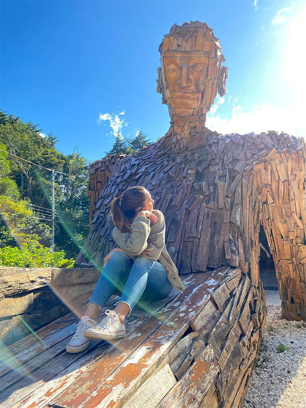 Une femme assise sur un banc en bois.