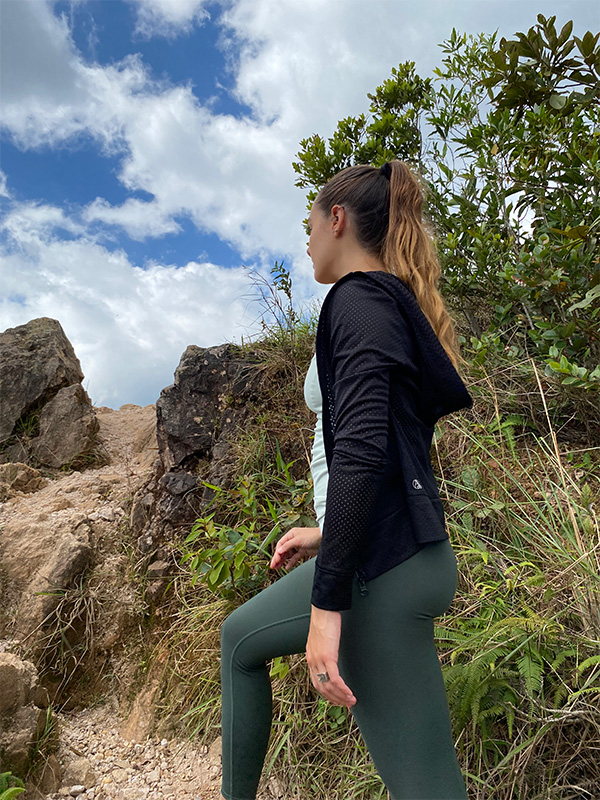 Une femme en haut noir et leggings verts