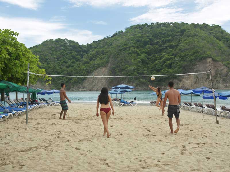 Un groupe de personnes jouant au volleyball sur une plage.