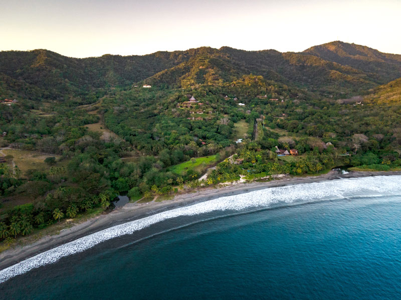 Une vue plongeante sur une plage et des montagnes.