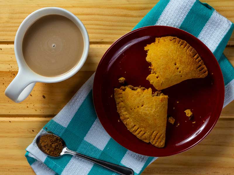 Deux morceaux de tarte dans une assiette à côté d’une tasse de café 