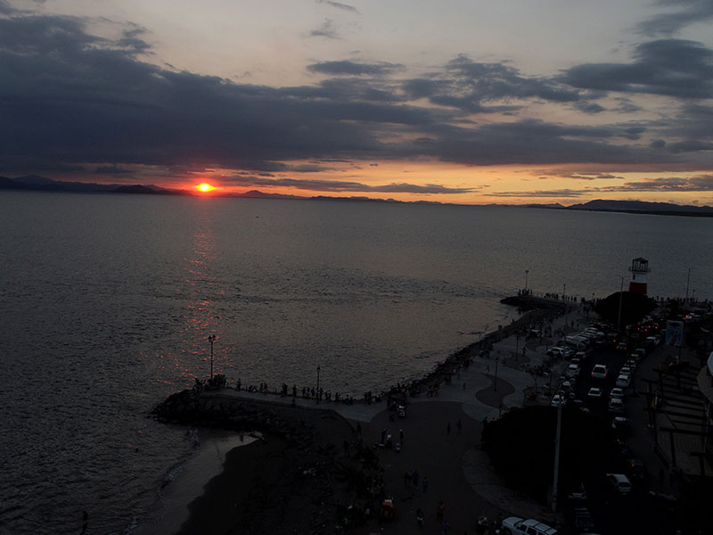 Une grande étendue d’eau avec un coucher de soleil en arrière-plan.