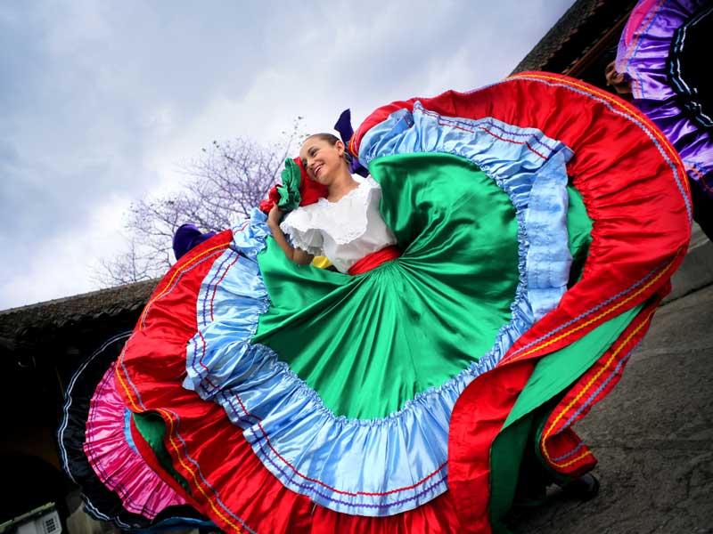 Une femme dans une robe colorée danse.