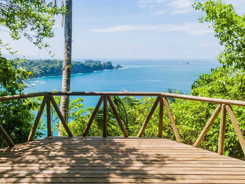 Une terrasse en bois avec vue sur l’océan.