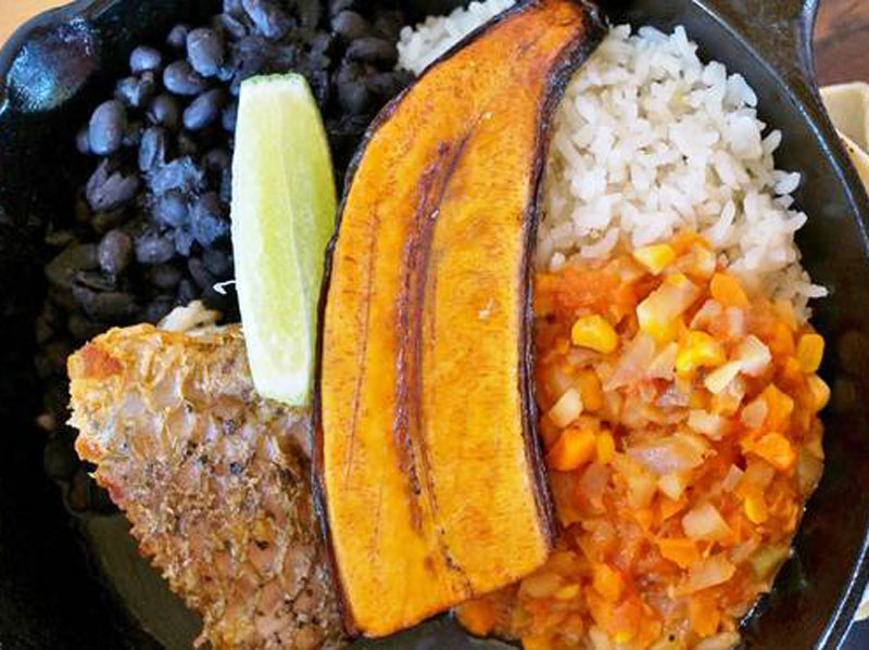 Une assiette de nourriture avec du riz, des haricots et de la viande.
