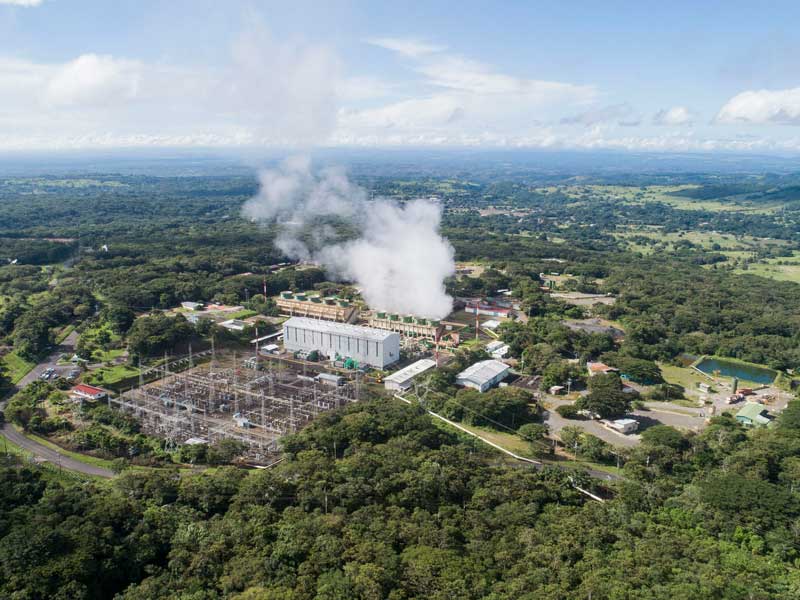 Vue aérienne d’une usine avec de la fumée qui en sort.