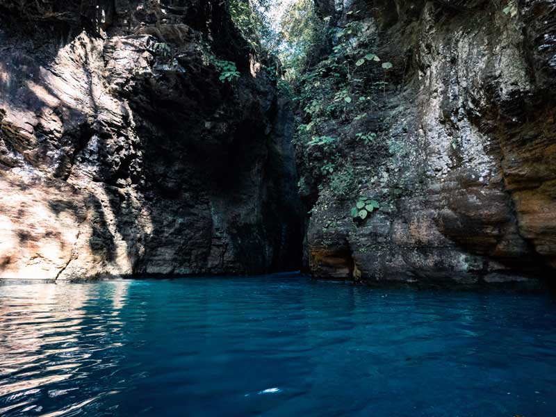 Un plan d’eau entouré d’une falaise rocheuse.