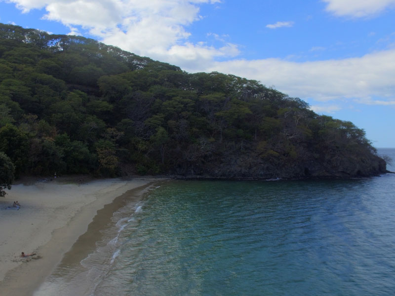 Une vue d’une plage avec une montagne en arrière-plan.