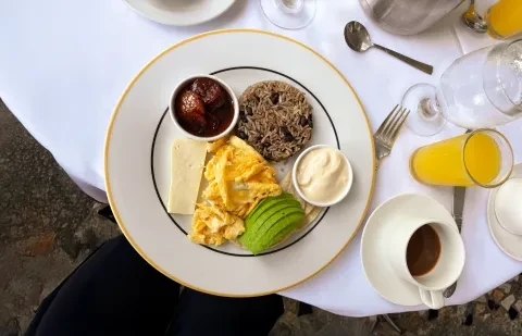 Assiette de petit-déjeuner sur une table avec un café et du jus d’orange
