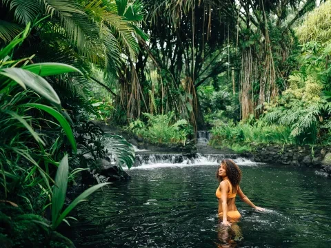 Femme marchant dans une source dans la jungle