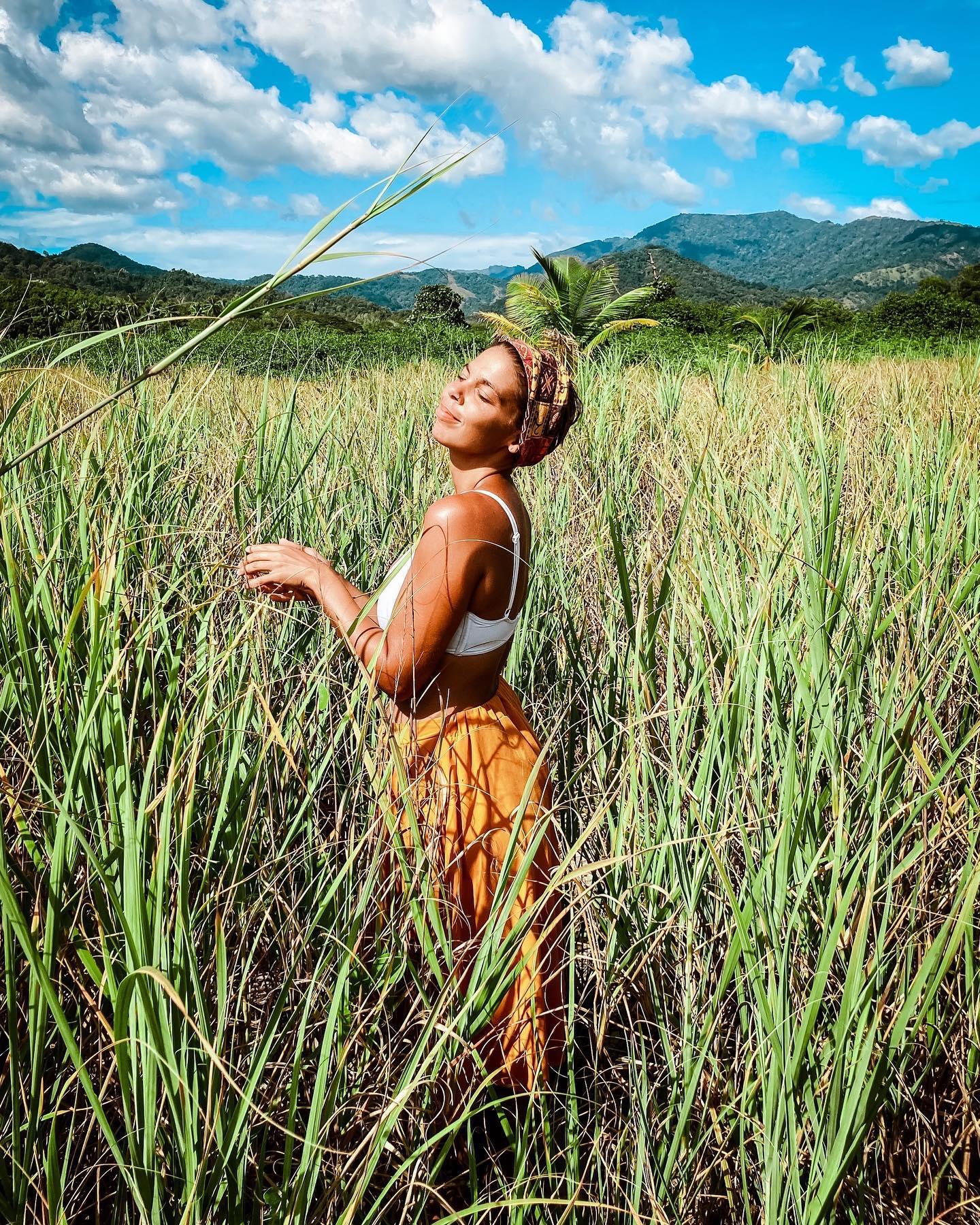 Une femme debout dans un champ d’herbes hautes