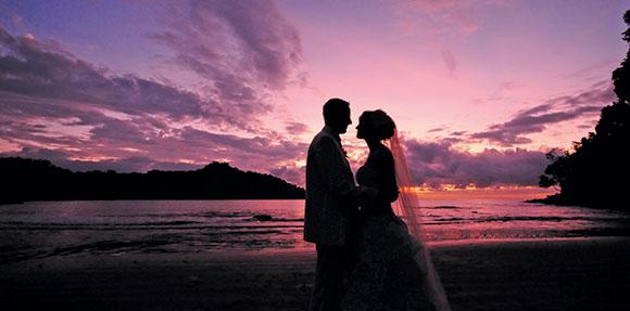 Les mariés sur la plage au coucher du soleil
