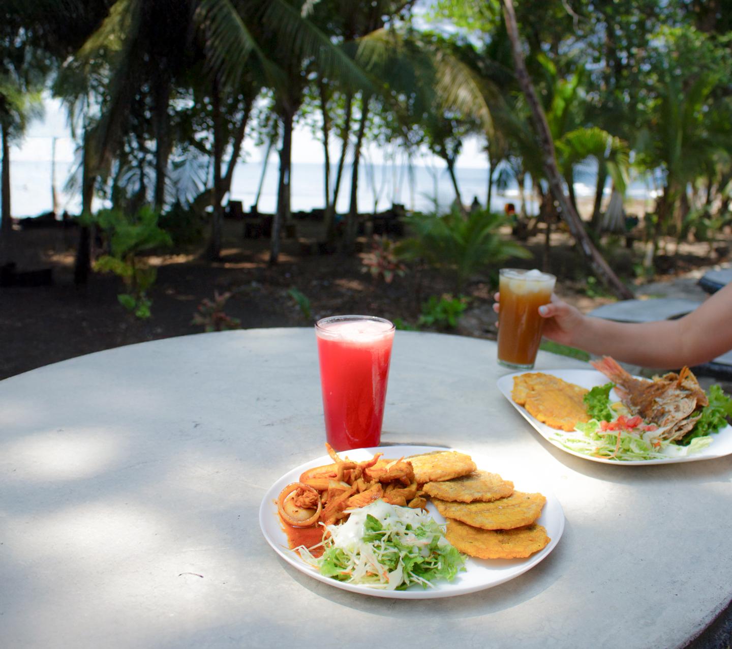 deux plats sur une table dehors avec vue sur la plage