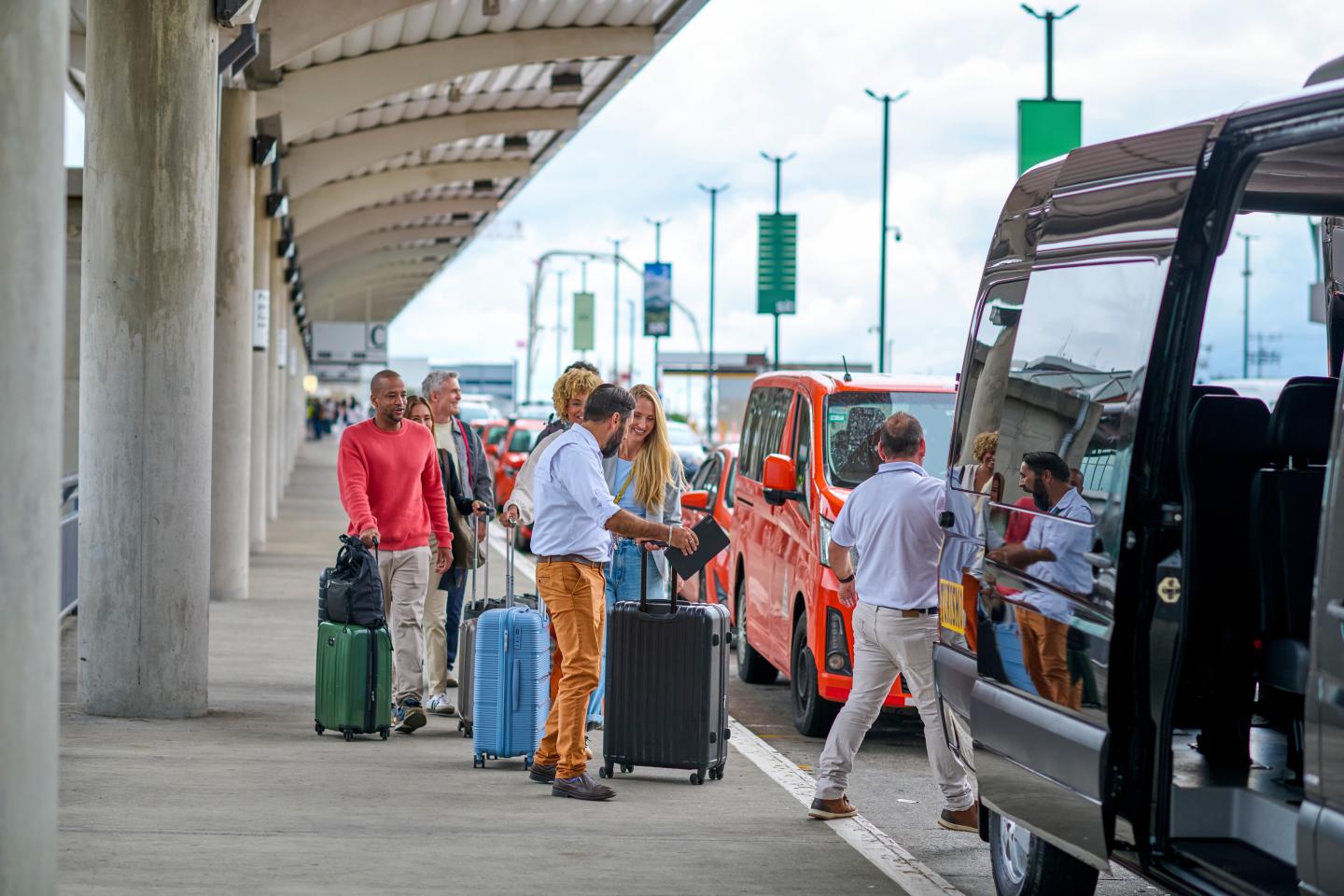 Homme aidant une famille avec des valises à l’aéroport