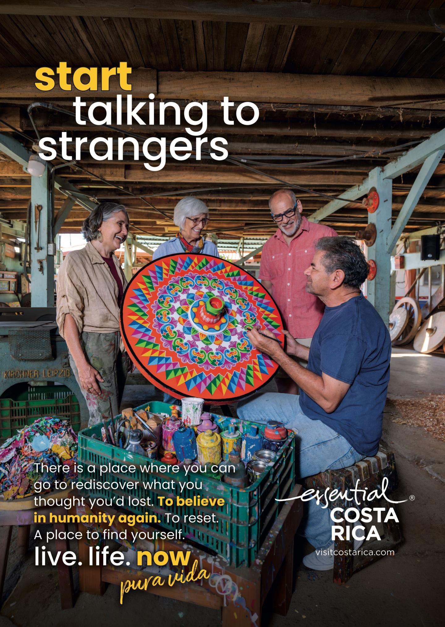 Publicité montrant quatre personnes dans un atelier discutant avec un artisan tenant une grande pièce circulaire peinte de couleurs vives. Titre : « commencez à parler à des inconnus ». Image de marque : « esencial Costa Rica", visitcostarica.com.